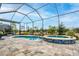 The screened-in pool area has a spa, and a view of the manicured backyard at 4748 Ballast Crest Cv, Land O Lakes, FL 34638