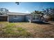 Exterior view of side and back of house and backyard, gray paint and lots of yard space at 5405 Golden Nugget Dr, Holiday, FL 34690
