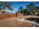 A spacious, fenced backyard with a small concrete patio and a fire pit at 5405 Golden Nugget Dr, Holiday, FL 34690