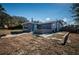 Exterior view of house and backyard with a small patio, gray paint and lots of yard space at 5405 Golden Nugget Dr, Holiday, FL 34690