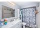 Cozy bathroom featuring a large vanity, white framed mirror, and marble-patterned shower curtain at 5405 Golden Nugget Dr, Holiday, FL 34690
