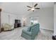 Bright living room with modern tile floors, a ceiling fan, and a comfortable seating area with a TV at 11045 Springridge Dr, Tampa, FL 33624