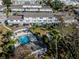 Aerial view of complex showing a pool, tennis court, shuffleboard court, and tropical landscaping at 1137 King Arthur Ct # 510, Dunedin, FL 34698