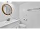 Clean bathroom with white vanity, modern faucet, and classic round mirror at 1137 King Arthur Ct # 510, Dunedin, FL 34698