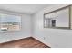 This bedroom has hardwood floors, a window and a decorative mirror at 1137 King Arthur Ct # 510, Dunedin, FL 34698