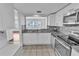 Bright kitchen featuring white cabinetry, stainless steel appliances, and tile backsplash at 1137 King Arthur Ct # 510, Dunedin, FL 34698