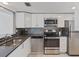 Modern kitchen with stainless steel appliances, mosaic backsplash, and ample counter space at 1137 King Arthur Ct # 510, Dunedin, FL 34698