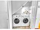 Laundry closet featuring a washer and dryer unit with shelving for storage at 1137 King Arthur Ct # 510, Dunedin, FL 34698