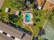 Aerial view of community pool featuring chairs, palm trees, and sunbathing spots at 1137 King Arthur Ct # 510, Dunedin, FL 34698