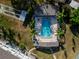 Aerial view of community pool, palm trees, lounge chairs, and clear blue water at 1137 King Arthur Ct # 510, Dunedin, FL 34698