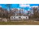Newly built manufactured home with gray siding, wooden steps, and fenced yard at 13017 Manatee Ave, New Port Richey, FL 34654