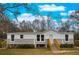 Modern manufactured home features gray siding, a white upper section, and a wooden staircase at 13017 Manatee Ave, New Port Richey, FL 34654