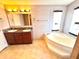 Bathroom featuring a double sink vanity and luxurious soaking tub, perfect for relaxation at 145 Blue Marlin Dr, Oldsmar, FL 34677