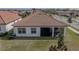 Aerial view of house showcasing a large backyard and screened patio at 16959 Scuba Crest St, Wimauma, FL 33598