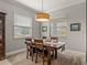 Bright dining room features a wood table with four chairs and large windows at 16959 Scuba Crest St, Wimauma, FL 33598