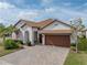 Beautiful one-story home with a tile roof, wooden garage door, and paved driveway at 16959 Scuba Crest St, Wimauma, FL 33598