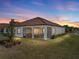 Home exterior showcasing a screened patio and well-maintained lawn at 16959 Scuba Crest St, Wimauma, FL 33598