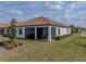 Rear view of the house with a screened patio and landscaped yard at 16959 Scuba Crest St, Wimauma, FL 33598