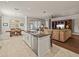 Open concept kitchen and Gathering room with island, hardwood floors, and a large TV at 16959 Scuba Crest St, Wimauma, FL 33598