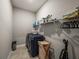 Convenient laundry room with washer, dryer, shelving, and hanging racks at 16959 Scuba Crest St, Wimauma, FL 33598