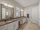 Double vanity bathroom with granite countertops and a large mirror at 16959 Scuba Crest St, Wimauma, FL 33598