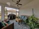 Relaxing screened patio with seating area, ceiling fan, and lush greenery at 16959 Scuba Crest St, Wimauma, FL 33598