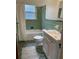 Clean bathroom with green tile and a white vanity at 2327 Woodlawn E Cir, St Petersburg, FL 33704