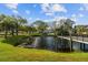 Serene pond with a wooden deck offering a peaceful waterfront view at 2402 Ecuadorian Way # 28, Clearwater, FL 33763