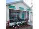 Charming home featuring a screened-in porch, turquoise door, and colorful landscaping at 301 E Grace St, Punta Gorda, FL 33950