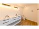 Bright bathroom featuring a double vanity, modern fixtures, and wood-look flooring at 3522 E 26Th Ave, Tampa, FL 33605