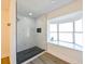Modern bathroom with a large walk-in shower, marble tile, and a window at 3522 E 26Th Ave, Tampa, FL 33605