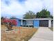 Cute blue house with a well-maintained lawn and driveway at 3546 Cheswick Dr, Holiday, FL 34691