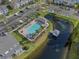 Aerial view of the community pool, dock, parking area, mature trees, and water feature at 388 Countryside Key Blvd, Oldsmar, FL 34677