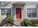Red front door entrance with landscaping and a welcome mat at 388 Countryside Key Blvd, Oldsmar, FL 34677