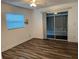 Bedroom with sliding glass doors and wood-look floors at 401 Dorchester Pl # 62, Sun City Center, FL 33573