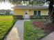Exterior view of a yellow single-story home with well-maintained landscaping at 401 Dorchester Pl # 62, Sun City Center, FL 33573