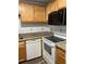 Galley kitchen with wood cabinets, granite counters, and stainless steel appliances at 401 Dorchester Pl # 62, Sun City Center, FL 33573