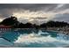 Large community swimming pool reflecting the sunset at 401 Dorchester Pl # 62, Sun City Center, FL 33573