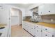 White kitchen cabinets, wood countertops, and tile flooring at 4711 Olive Dr, Zephyrhills, FL 33542