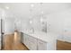 Spacious kitchen with white cabinets, island, and hardwood floors at 5936 Golden Nettle Dr, Apollo Beach, FL 33572
