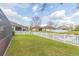 Lush backyard with a pond view, white picket fence, and mature trees at 6722 Boulder Run Loop, Wesley Chapel, FL 33545