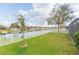 Expansive backyard with lush lawn, white picket fence, and scenic pond view at 6722 Boulder Run Loop, Wesley Chapel, FL 33545