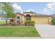Charming single-Gathering home featuring well-maintained landscaping, a stone-accented facade, and an attached two-car garage at 6722 Boulder Run Loop, Wesley Chapel, FL 33545