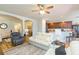 Open-concept living room featuring hardwood floors, ceiling fan, and an archway to the kitchen at 6722 Boulder Run Loop, Wesley Chapel, FL 33545