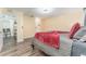 Bright bedroom with gray bedding, wood-look floors, and access to a bathroom at 734 Fortuna Dr, Brandon, FL 33511