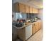 Galley kitchen with light wood cabinets and appliances at 7614 Karen Dr, Port Richey, FL 34668