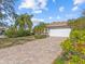 Front view of the house with a brick driveway and mature trees at 805 Anchors Way, Tarpon Springs, FL 34689