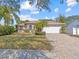 Single-story home with a paved driveway and lush landscaping at 805 Anchors Way, Tarpon Springs, FL 34689