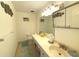 Well-lit bathroom with a large vanity, sink, and a neutral-colored tile floor at 100 Bluff View Dr # 401A, Belleair Bluffs, FL 33770