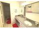 Bathroom featuring an extended vanity with a sink and heart-shaped rugs on the tile floor at 100 Bluff View Dr # 401A, Belleair Bluffs, FL 33770